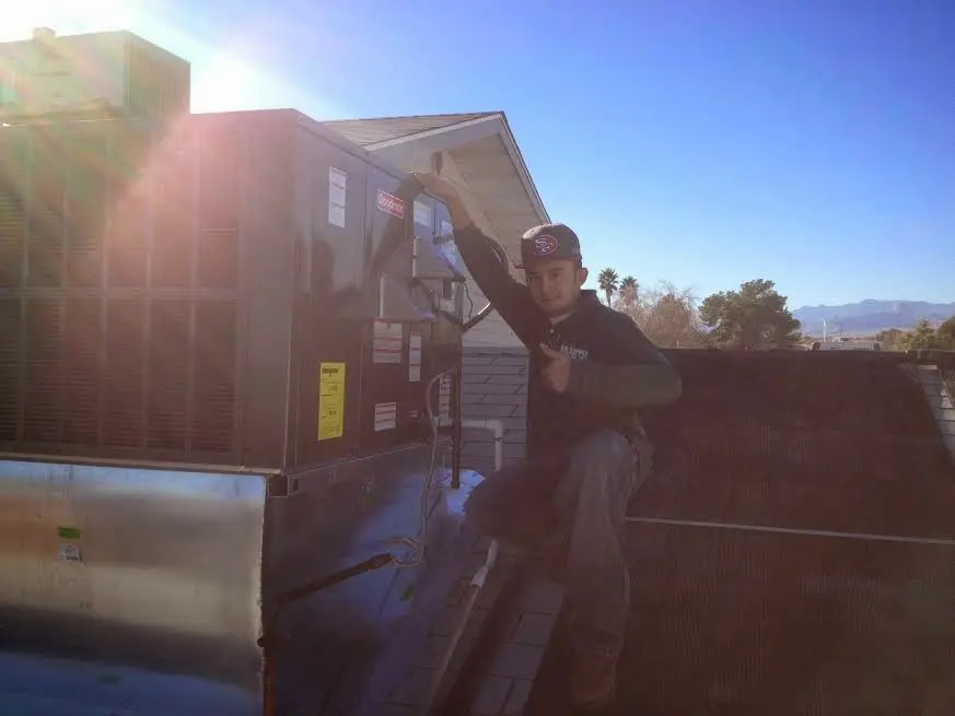 HVAC technician performing AC Tune-Up on a rooftop unit in Laplace